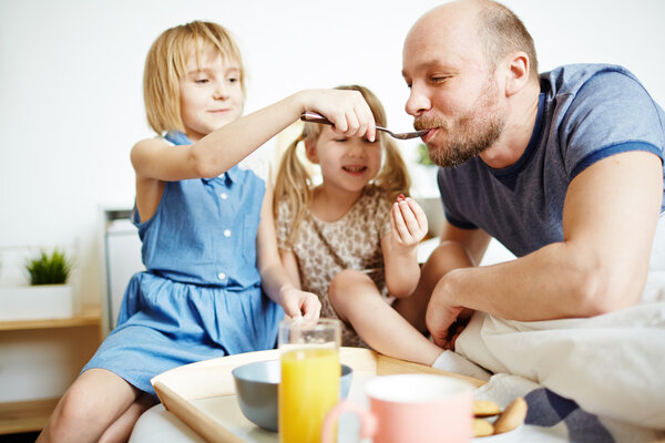 father and daughters with breakfast