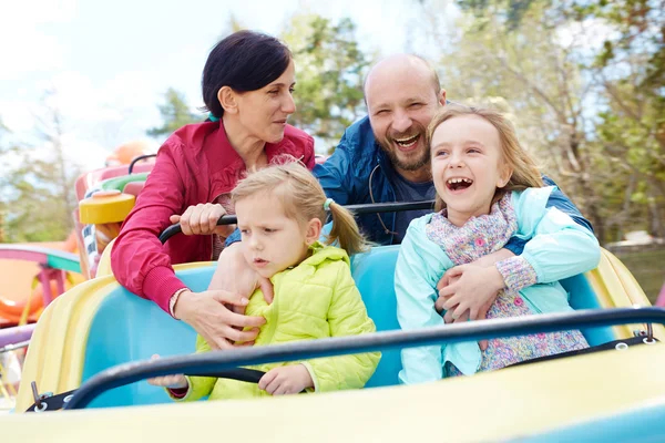Niños y padres en el parque de atracciones — Foto de Stock