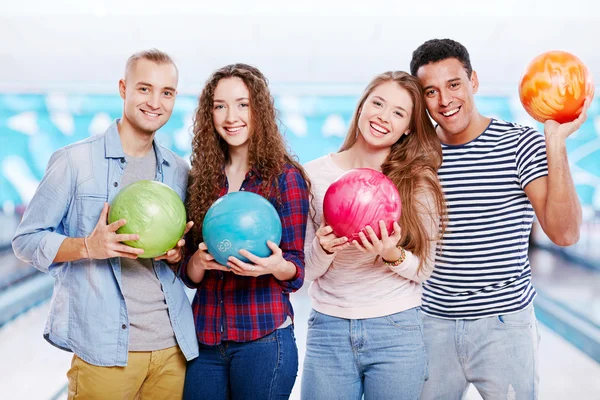 Freunde mit Bowlingbällen — Stockfoto