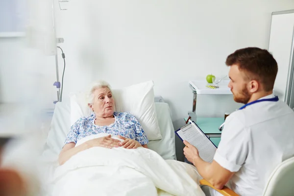 Médico sentado na cama — Fotografia de Stock