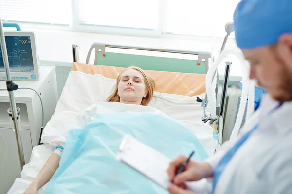 Unconscious woman lying on bed — Stock Photo, Image