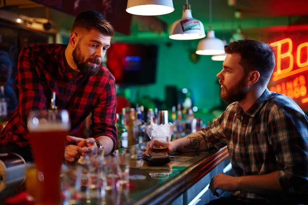 Barman och vän pratar i pub — Stockfoto