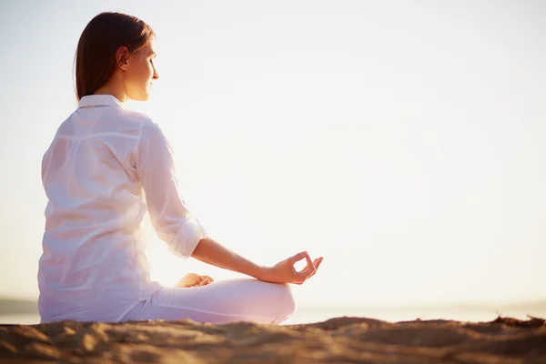 Woman sitting in pose of lotus — Stock Photo, Image