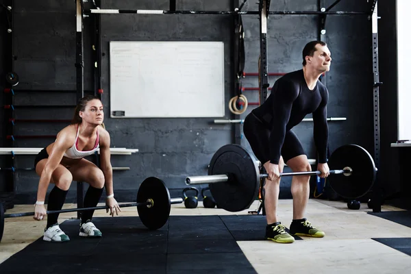 Erkek ve kadın barbell kaldırma — Stok fotoğraf