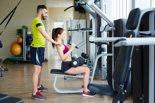 Trainer helping fit woman — Stock Photo, Image