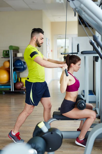 Trainer helping fit woman — Stock Photo, Image