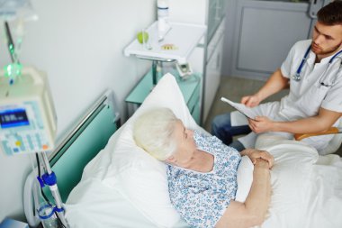 Yatağa oturan doktor