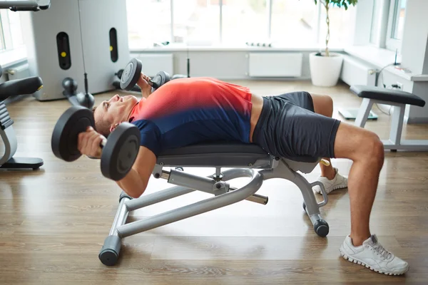 Bodybuilder working out with dumbbells — Stock Photo, Image