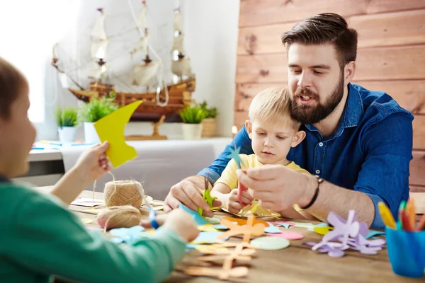 Man and sons making figures — Stock Photo, Image
