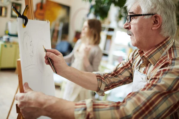 Homem sênior desenho no cavalete — Fotografia de Stock