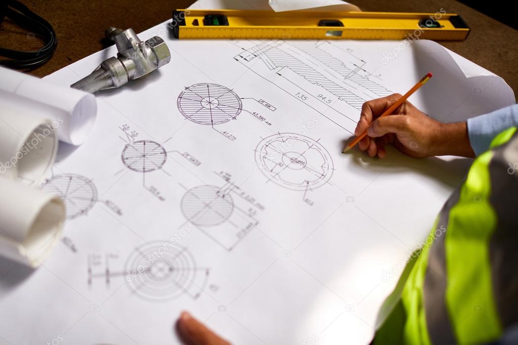 Engineer drawing sketch of machine part