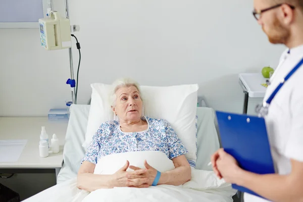 Старшая женщина разговаривает со своим врачом — стоковое фото