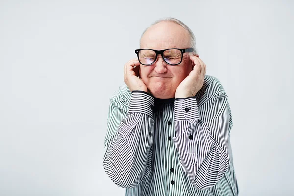 Senior berührte seine Schläfen — Stockfoto