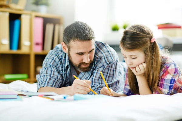 Дочь и отец делают домашнее задание — стоковое фото
