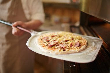 Şef holding ham pizza 