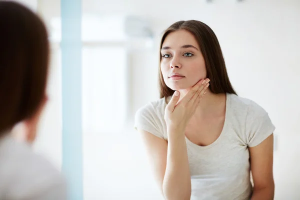 若い女性が彼女の顔を見て — ストック写真