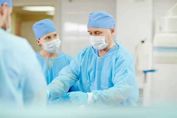 Senior chirurg werkzaam met team — Stockfoto