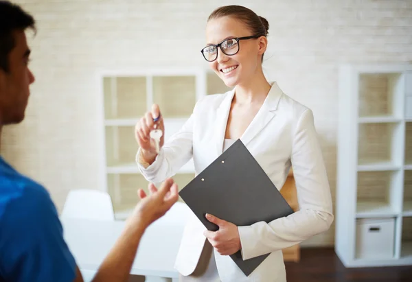 Femme passe la clé à son client — Photo