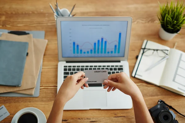 Mãos segurando cartão de crédito sobre laptop — Fotografia de Stock