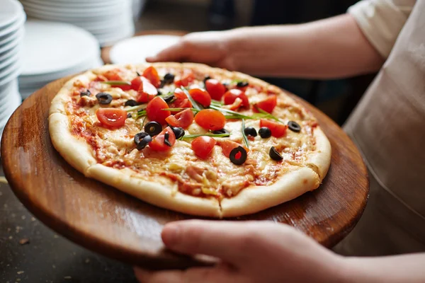 Koch bringt leckere Pizza mit — Stockfoto