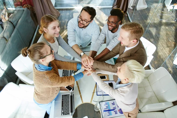 Ondernemers maken van stapel van handen over werkplek — Stockfoto