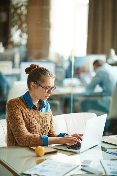 Kvinnlig anställd att skriva på laptop i office — Stockfoto