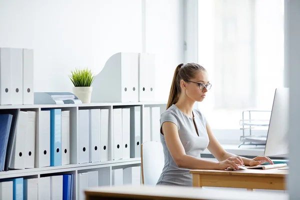 Empresária sentada na frente do laptop no escritório — Fotografia de Stock