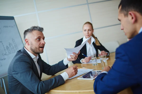 Бизнесмен беседует с коллегами во время встречи — стоковое фото