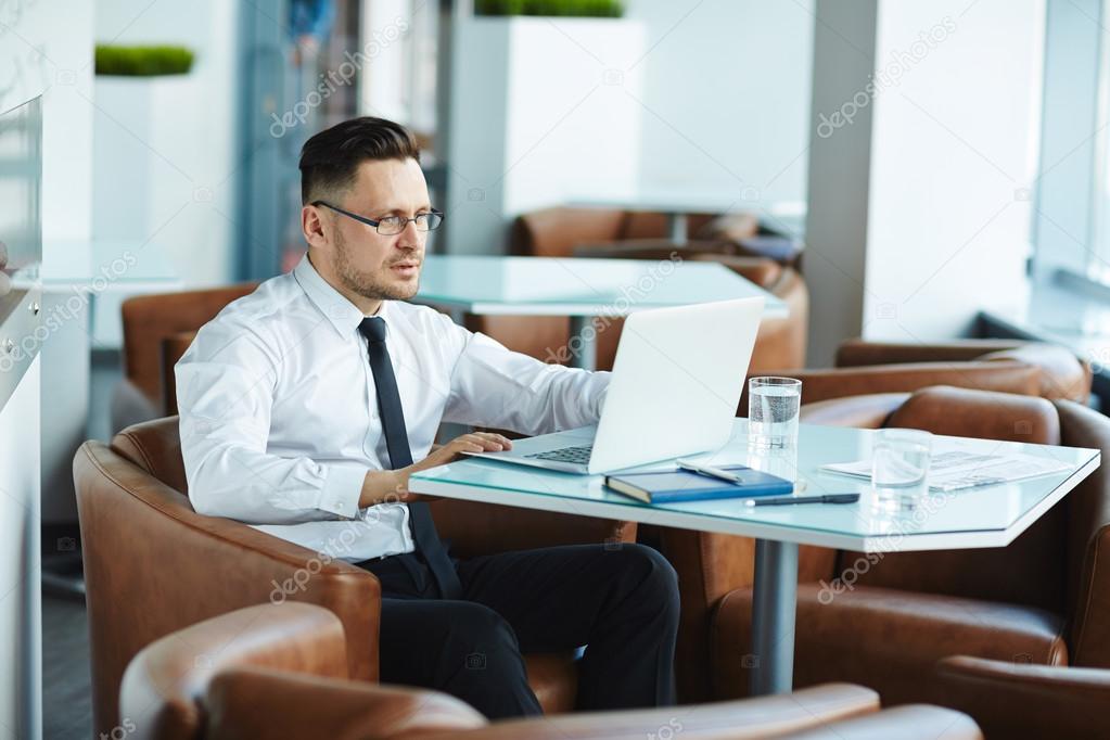 Businessman using laptop in cafe