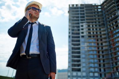 İşadamı inşaat alanı üzerinde koruyucu kask içinde