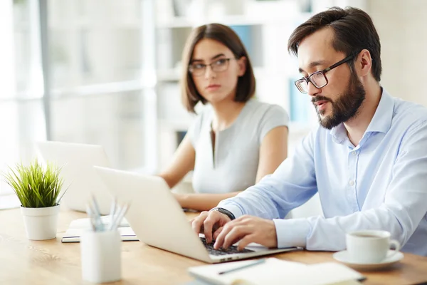 Homem de negócios sério digitando no laptop — Fotografia de Stock