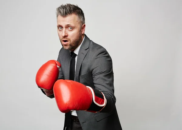 Empresario en guantes de boxeo atacando rival — Foto de Stock