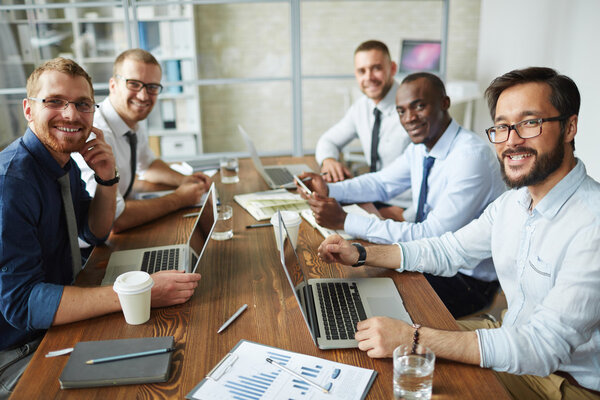 Successful employees sitting by table