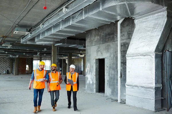 Engenheiros que se deslocam para baixo canteiro de obras — Fotografia de Stock