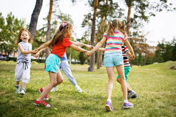 Barn med ringdans på gräs — Stockfoto