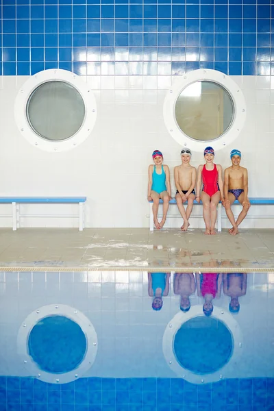 Kinderen zitten bij zwembad — Stockfoto