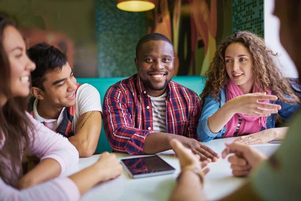 Multi-ethnic friends talking in cafe — Stock Photo, Image