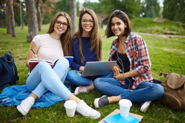 Grup çimlerde okuyan öğrenci