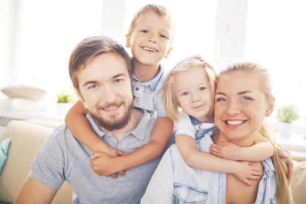 Vrolijke ouders en hun kinderen thuis — Stockfoto