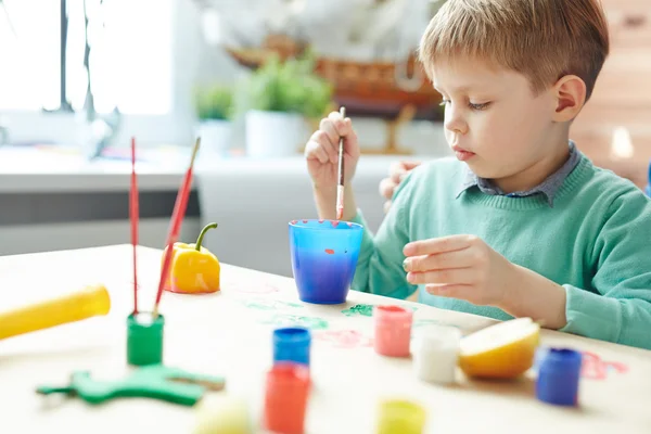 Junge macht Pfefferabzüge mit Gouache — Stockfoto