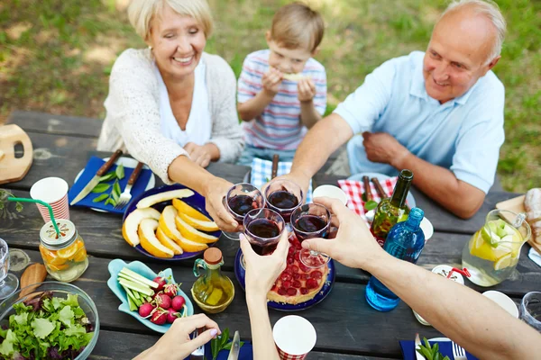 Les gens avec du vin grillé sur la table servie — Photo