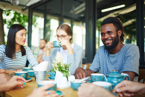 Межкультурные друзья проводят время в кафе
 