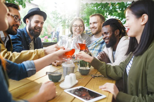 Gente feliz brindando con bebidas en la cafetería —  Fotos de Stock