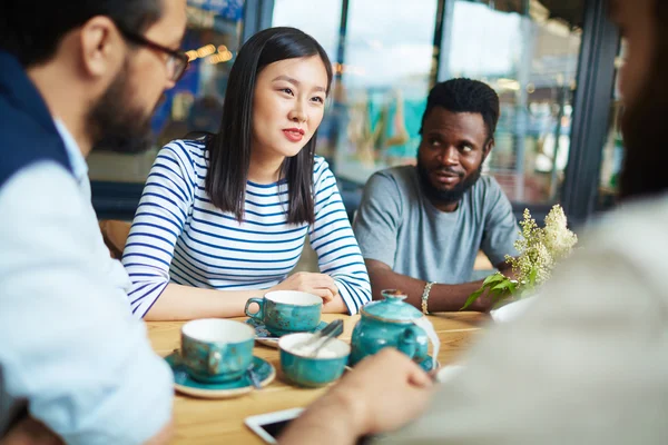 Intercultural friends relaxing in cafe — Stock Photo, Image
