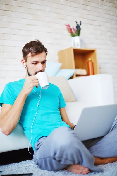 Young man networking at home — Stock Photo, Image