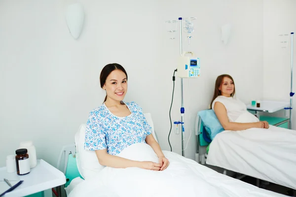 Happy women lying in bed in hospital — Stock Photo, Image