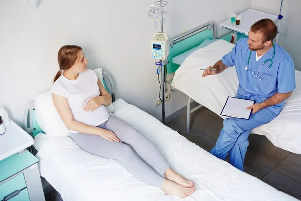 Pregnant woman talking to doctor — Stock Photo, Image