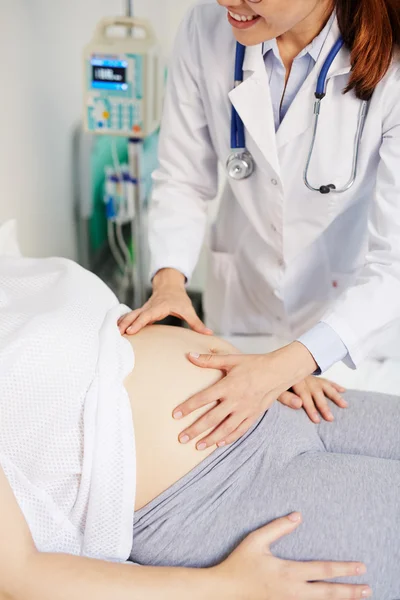 Jovem médico examinando barriga — Fotografia de Stock