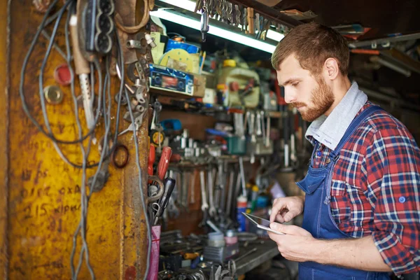 Serious mechanic with touchpad — Stock Photo, Image