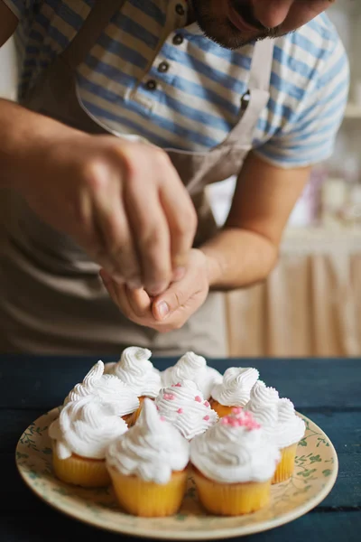 Homem que decora muffins — Fotografia de Stock